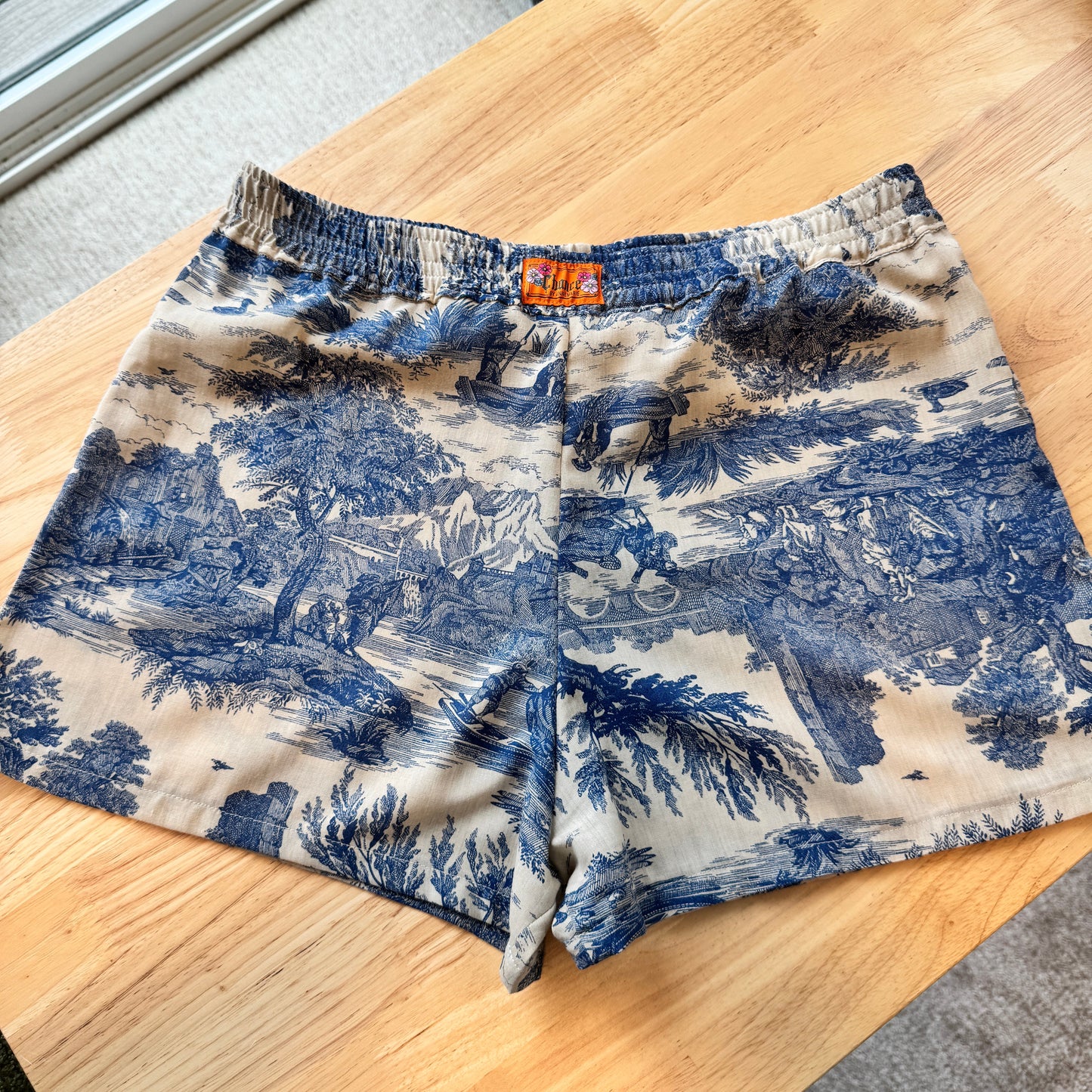 Blue and white patterned shorts on a wooden table