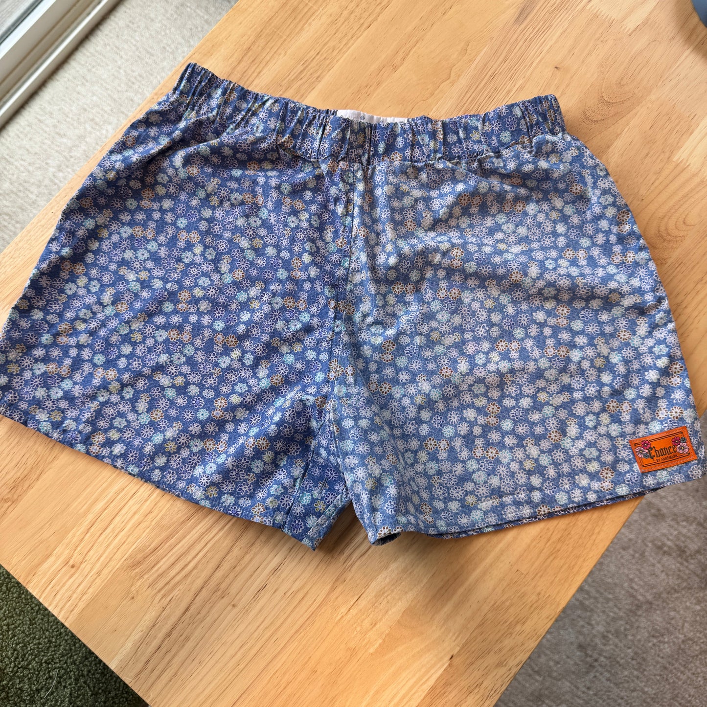 Blue floral-patterned shorts on a wooden table
